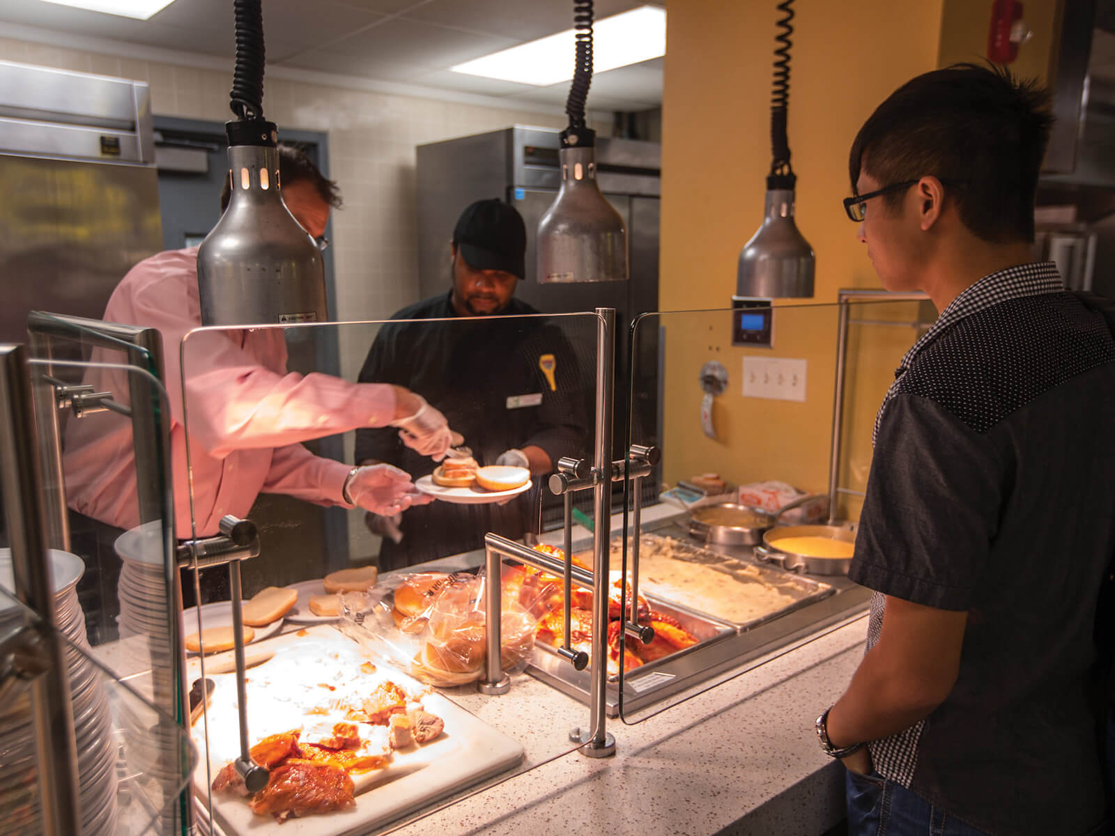 A photo of FIU dining staff serving food at 8th Street Kitchen