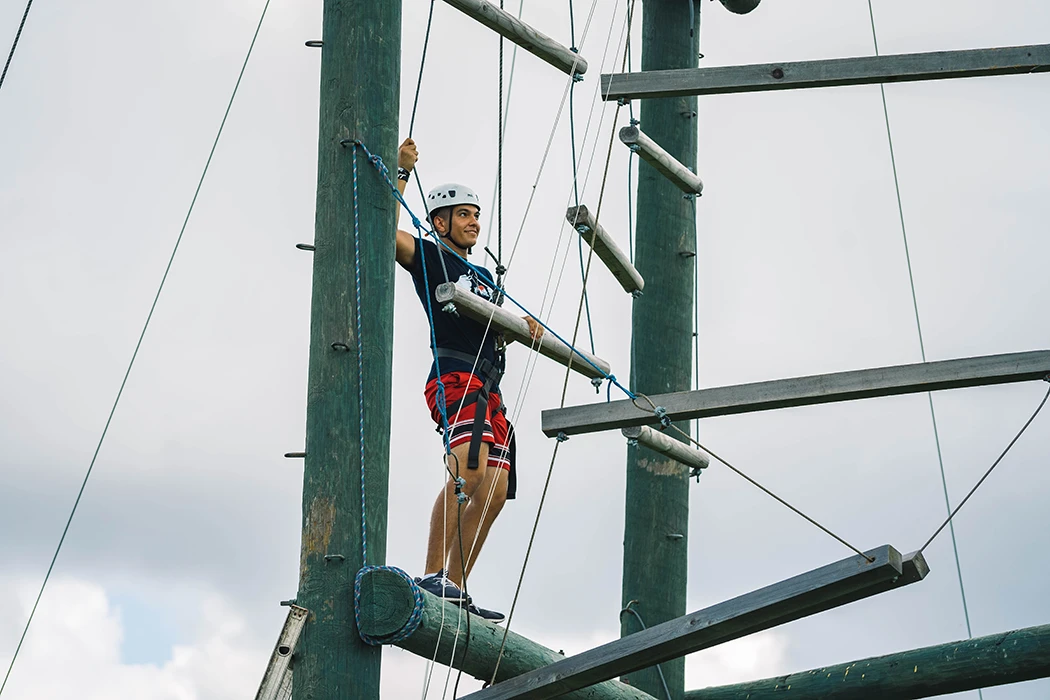 A student about to start crossing the rope course.