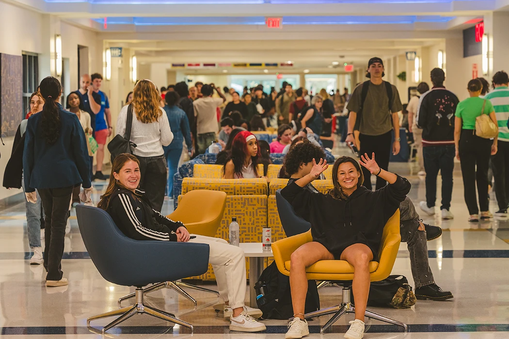 Two students sitting in GC smiling at the camera.