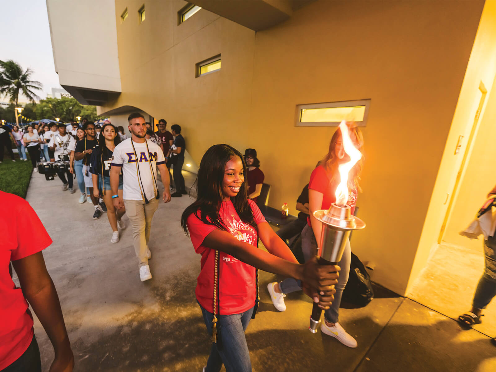 A photo of an FIU student holding the torch