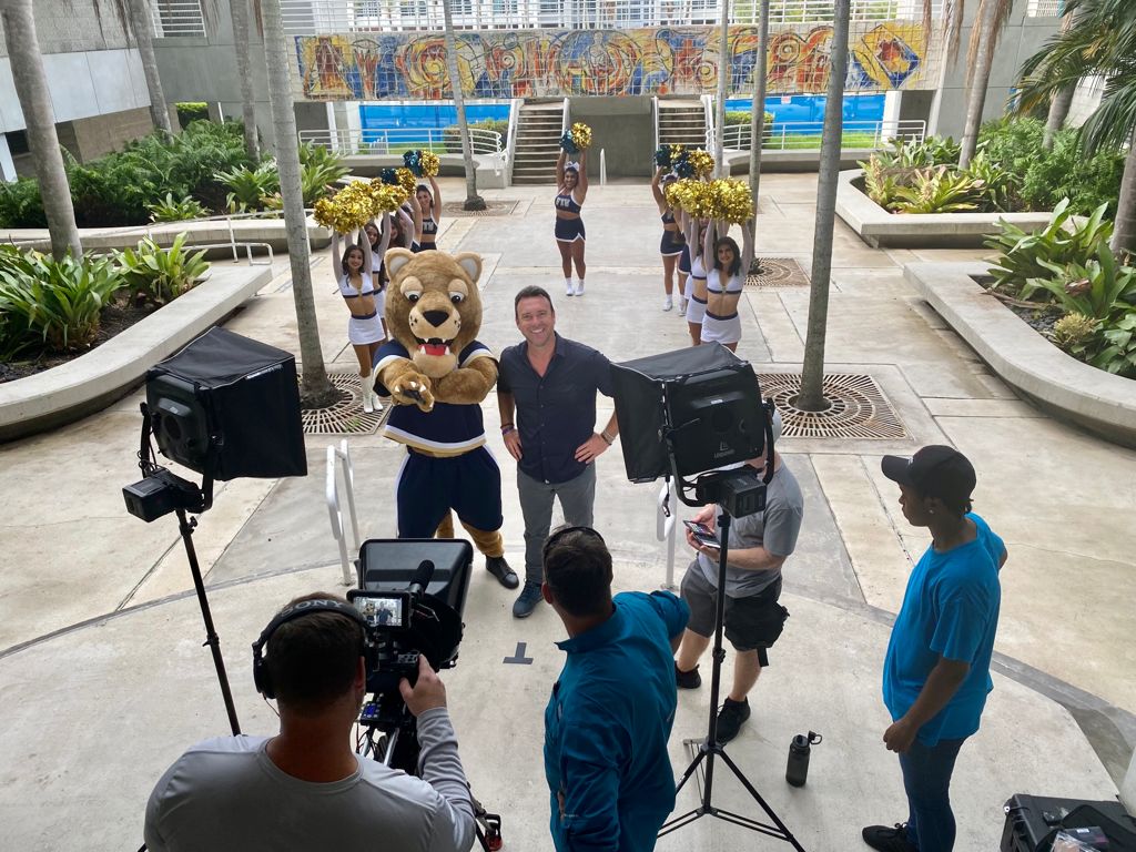 Alex Boylan, host of The College Tour, filming a segment with the FIU mascot and cheer and dance teams outside of the College of Arts, Sciences and Education building.