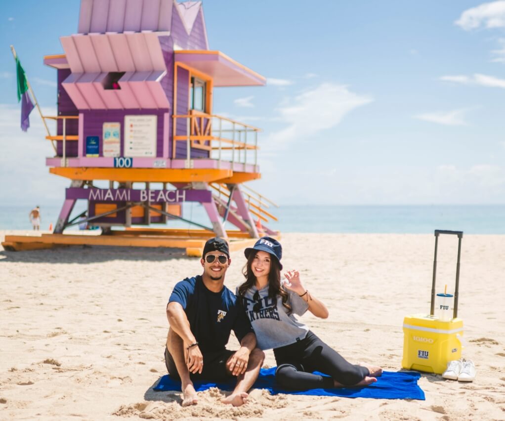 FIU transfer students sit in the sand by a Miami Beach lifeguard house