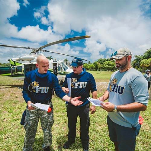 The FIU Fast team standing in front of a helicopter