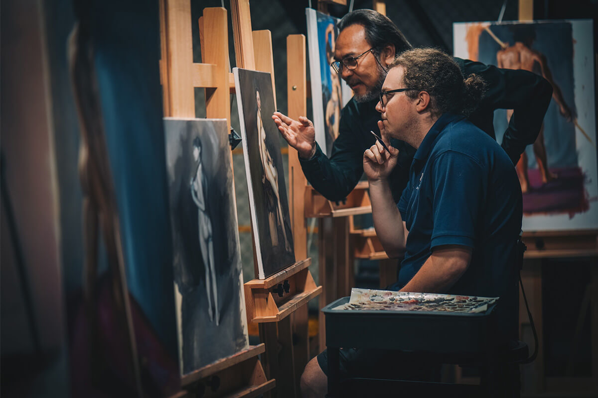 David Chang giving an FIU student advice on his latest painting