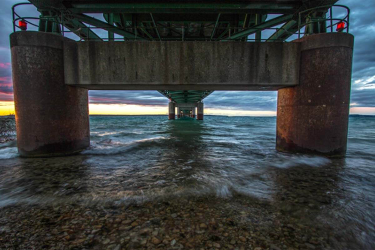 A view of the ocean from underneath a pier 