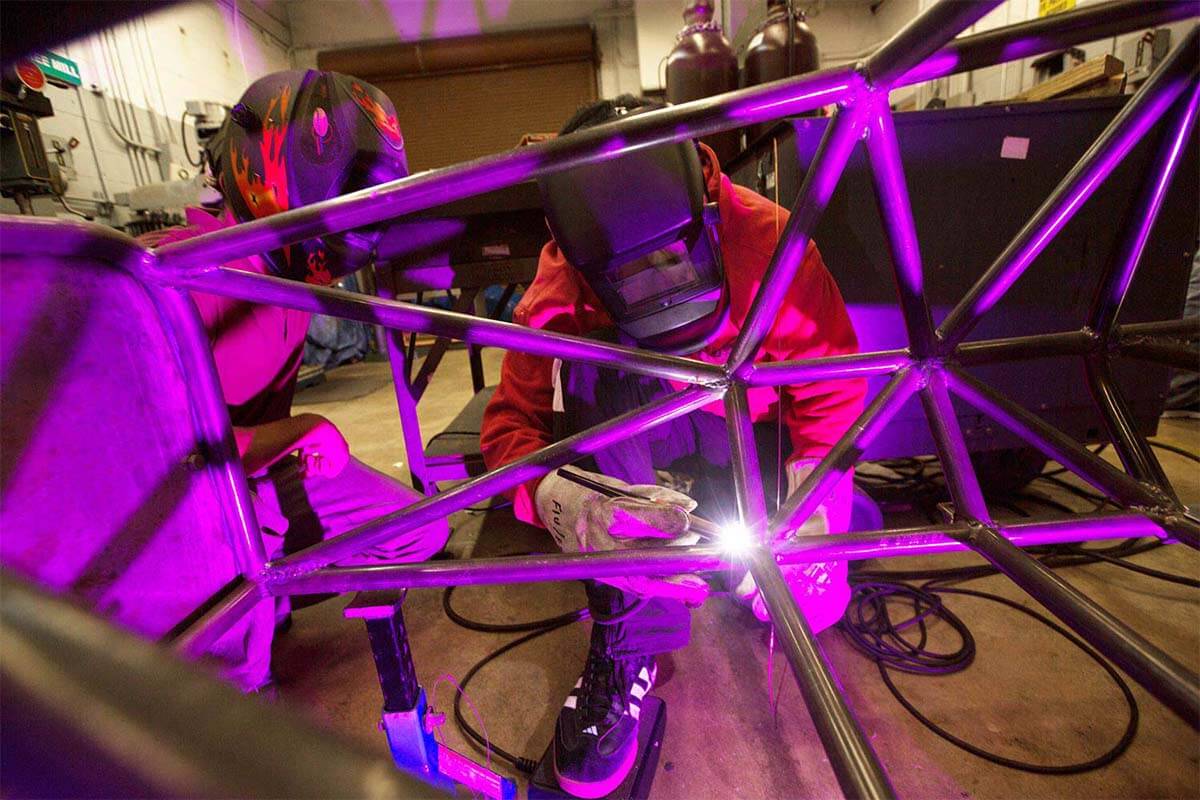 A student welding together a race car